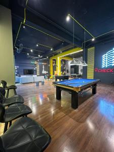 a ping pong table in a room with chairs at AuraStays in Dargai +10 photos