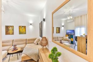 a living room with a couch and a mirror at IPM Apartments Kaštela, parking, pool, 10 minutes from Split airport in Kaštela