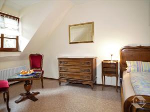 a bedroom with a bed and a dresser and a chair at Ferienwohnung Alte Schmiede in Burkheim