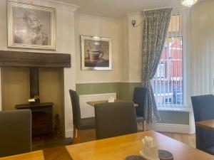 a dining room with a table and a fireplace at The Libra - Adults Only B&B with guaranteed carpark in Blackpool