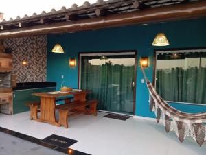 a room with a wooden table and a hammock at Recanto das Oliveiras in Corumbau
