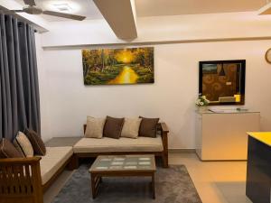 a living room with a couch and a painting on the wall at Oval View Residencies By C in Colombo