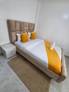 a bedroom with a bed with yellow pillows at Waridi Homes-2 BR Naivegas Apartments, Naivasha in Munyu
