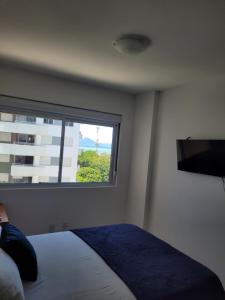 a bedroom with a bed and a large window at Ap Royal Mirage in Florianópolis +34 photos