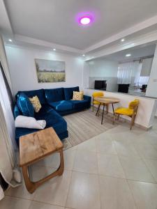 a living room with a blue couch and a table at Waridi Homes-2 BR Naivegas Apartments, Naivasha in Munyu
