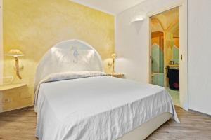 a bedroom with a white bed in a room at Yacht Terrace - Exclusive Waterfront View Porto Cervo Center - by Coral Property in Porto Cervo