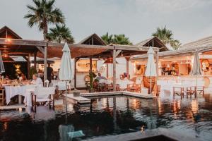 a restaurant with tables and chairs next to a swimming pool at Kon Tiki in Saint-Tropez