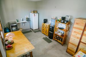 a kitchen with a table and a refrigerator at Chalé sol de Macapá 1- Refúgio Pertinho do Mar in Luis Correia