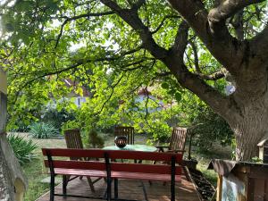 a wooden bench sitting under a tree with a table at Ferien und Monteurswohnung am Schloss in Bopfingen
