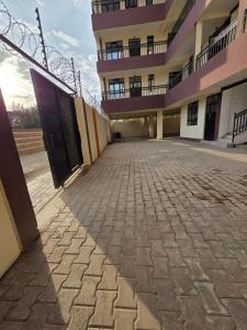an empty parking lot in front of a building at Waridi Homes-2 BR Naivegas Apartments, Naivasha in Munyu +2 photos