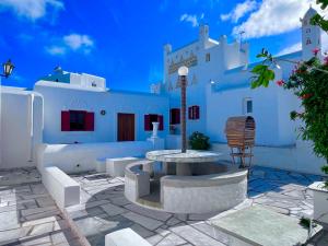 a patio with a table and chairs in front of a building at Villa Vasilis in Mikonos