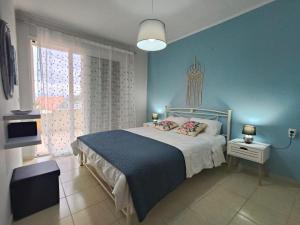 a bedroom with a bed and a blue wall at Dreamy Apartments Corfu in Kontokali +150 photos
