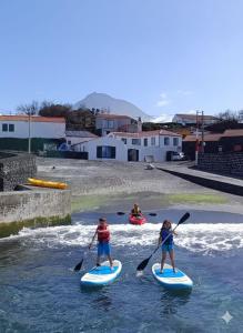 two people on paddle boards in a river at Casa do Guardião in Madalena