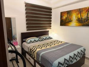 a bedroom with a bed and a painting on the wall at Oval View Residence by C in Colombo +7 photos