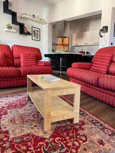 a living room with red couches and a piano at Relax Luino vista lago Casa LEA in Luino
