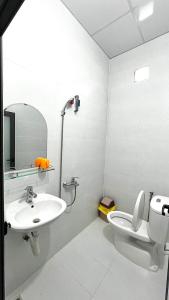 a white bathroom with a sink and a toilet at Nhà Nghỉ Như Ý in Phan Rang–Tháp Chàm