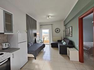 a kitchen and living room with a couch and a refrigerator at Dreamy Apartments Corfu in Kontokali