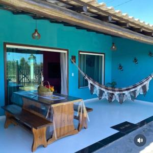 a blue room with a table and a hammock at Recanto das Oliveiras in Corumbau