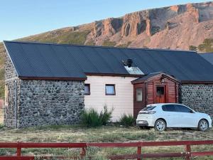 a white car parked in front of a stone house at Cabañas Las Cascadas in Caviahue