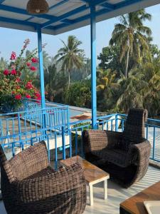 two chairs and a table on a deck with a view of the ocean at Himandhoo sweet dreams in Himandhoo 