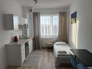 a small room with a bed and a kitchen at VESTA Apartamenty P23 in Szczecin +39 photos
