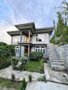 a white house with some flowers and stairs at verse hunza in Karimabad Hunza