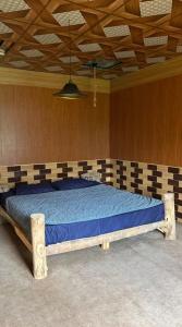 a large bed in a room with a wooden ceiling at verse hunza in Karimabad Hunza +9 photos