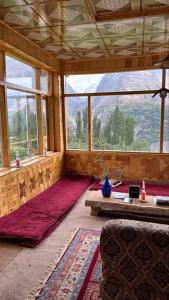 a living room with a large window and a couch at verse hunza in Karimabad Hunza