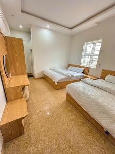 a bedroom with two beds and a window at Tay Bac Hotel in Mộc Châu +12 photos
