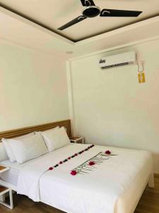 a bedroom with a white bed with roses on it at Himandhoo sweet dreams in Himandhoo 