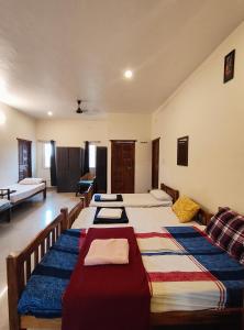 a large room with four beds in it at Art cafe in Auroville