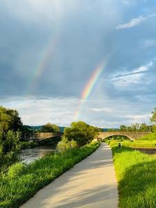 a rainbow over a road next to a river at Mobile-Home Living in Gilsdorf