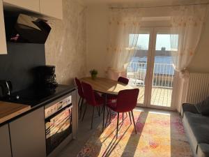 a kitchen with a table and chairs and a kitchen with a balcony at Apartments Let Me In in Pörtschach am Wörthersee