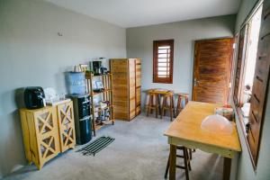 a room with a table and some wooden cabinets at Chalé Sol de Macapá 2 - Kitesurf, Vento & Paraíso in Luis Correia