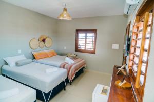 a bedroom with a bed and a couch and a table at Chalé Sol de Macapá 2 - Kitesurf, Vento & Paraíso in Luis Correia