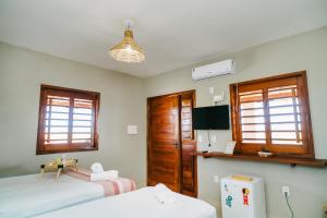 a bedroom with two beds and two windows at Chalé Sol de Macapá 2 - Kitesurf, Vento & Paraíso in Luis Correia +20 photos