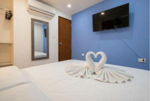two white swans in a bedroom with a tv on a bed at Hotel Getsemaní Central in Cartagena de Indias