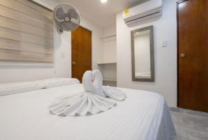 a bedroom with a white bed with a dress on it at Hotel Getsemaní Central in Cartagena de Indias +14 photos