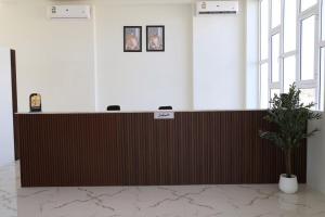 a reception desk in a room with a potted plant at فندق الحزم الرستاق Alhazm Hotel Alrustaq in Ḩazm