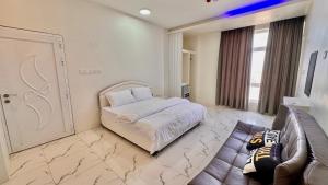 a bedroom with a bed and a couch and a door at فندق الحزم الرستاق Alhazm Hotel Alrustaq in Ḩazm +38 photos