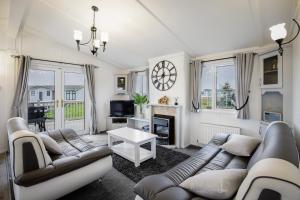 a living room with couches and a fireplace at Tranquil Lodge with river views in Hambleton