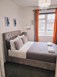a large bed in a bedroom with a window at Elisha's City Apartment in Hackbridge
