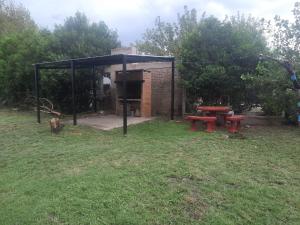 a picnic shelter with two picnic tables in a field at Cabaña Puntana in La Punta