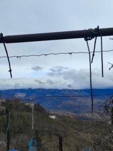 a view of the mountains through a wire fence at Sokaku Apartment in Gjirokastër