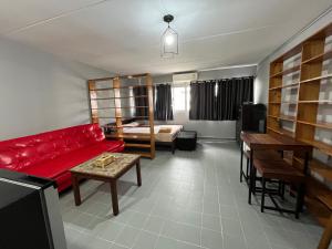 a living room with a red couch and a table at Impact Arena C5 by Jintana in Thung Si Kan