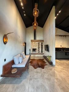 a living room with a couch and a fireplace at Rancho Mavi Hospedagem Colônia Witmarsum in Palmeira
