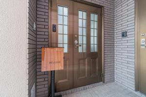 a brown door with a sign in front of it at Guest Houseふくふく in Shimonoseki