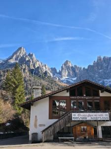 a building with mountains in the background at Hope Home Trentino in San Martino di Castrozza