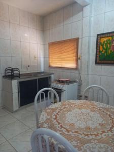 a kitchen with a table and a stove and a table and chairs at Casa Conforto e Aconchego com garagem e internet próximo ao centro in Pesqueira +11 photos