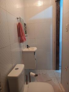 a white bathroom with a toilet and a sink at Casa Conforto e Aconchego com garagem e internet próximo ao centro in Pesqueira